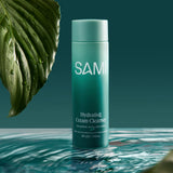 Hydrating cream cleanser by SAMI with hyaluronic acid and gotu kola no rinse face cleanser on water with botanical leaf.